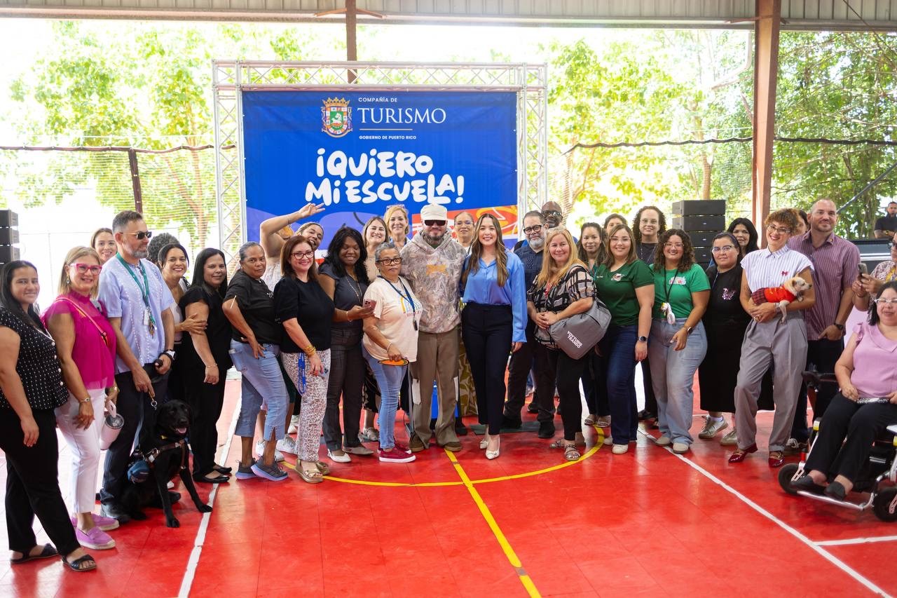 La directora ejecutiva de la Compañía de Turismo de Puerto Rico, Willianette Robles Cancel, y el artista urbano Farruko acompañados de personal del plantel y la facultad de la escuela Gabriela Mistral.